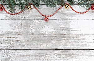 Old wooden Christmas background. Fir branches. Gold and red baubles. Red garlands. Xmas card. Top view. Space for your text.