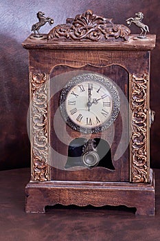 Old wooden clock with pendulum on leather