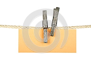 Old wooden clothespin holding brown paper on a white background