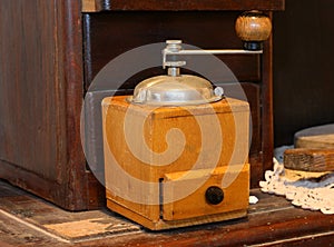 old wooden coffee grinder to pulverize the beans and prepare the drink photo