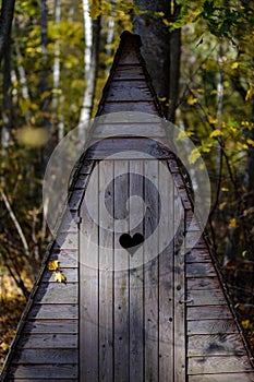 old wooden countryside toilet house with heart shaped hole in th