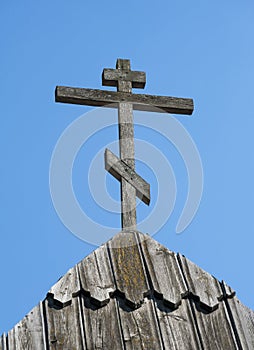 Old wooden cross against blue sky