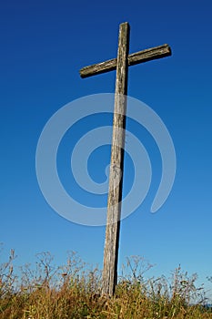 Old wooden cross against a blue sky background