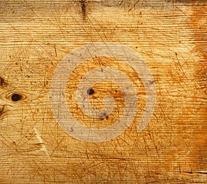 Old wooden cutting board with multiple signs of scoring as a background