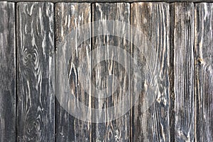 Old wooden dark background consisting of shabby black-brown textured boards.