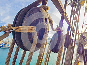 Old wooden deadeye on the shrouds of a tall ship of the eighteenth century in the sunlight