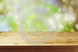 Old wooden deck table with spring bokeh background. Ready for product display montage. photo