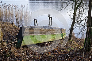 Old wooden dinghy or rowboat on a lake shore