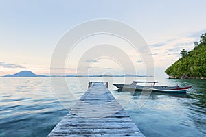 Old wooden dock at the lake with traditional boat, sunset shot