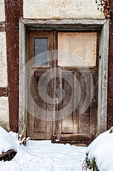 Old door in an abandoned house in winter