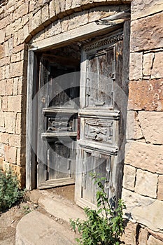 Old wooden door in abandoned ruined house in ancient village Gamsutl, Dagestan