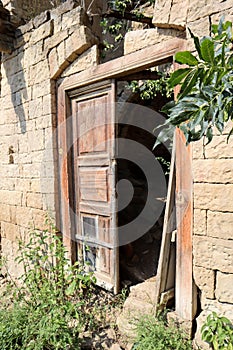 Old wooden door in abandoned ruined house in ancient village Gamsutl, Dagestan