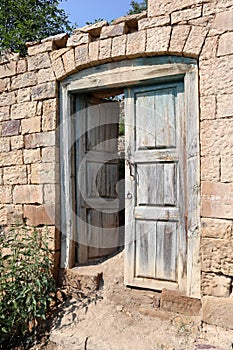 Old wooden door in abandoned ruined house in ancient village Gamsutl, Dagestan