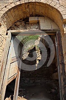 Old wooden door in abandoned ruined house in ancient village Gamsutl, Dagestan