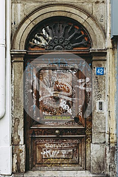 Old wooden door with an arch and tags - Vandalism
