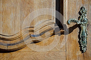 Old wooden door with a beautiful decorative metal door handle. entrance to the old church