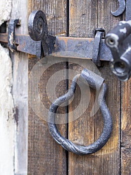 Old wooden door with black metal deadbolt photo