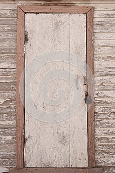 An old wooden door with a closed iron padlock