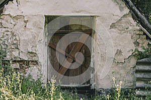 Old wooden door closed with a metal lock in a rustic cellar, closeup