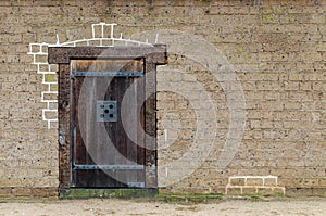 Old wooden door closeup, front view, brick wall