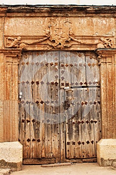 Old wooden door and coat of arms of the Holy Inquisition