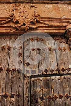 Old wooden door and coat of arms of the Holy Inquisition