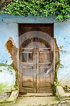 Old wooden door & dilapidated blue wall