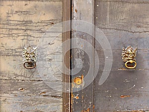 Old wooden door with door knockers and keyhole close up