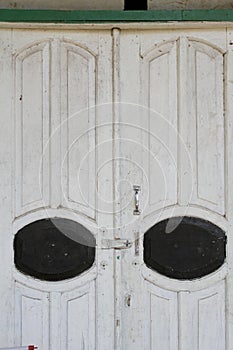 Old wooden door with dull white and black paint