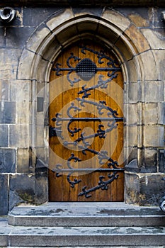 Old wooden door with forged pattern in Gothic style. Prague Castle - Gothic architecture of st. Vitus cathedral back door. Czech