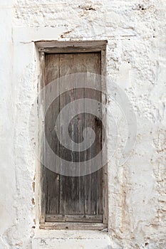 Old wooden door on grunge weathered wall.