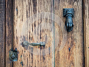 Old wooden door with a hand shaped knob