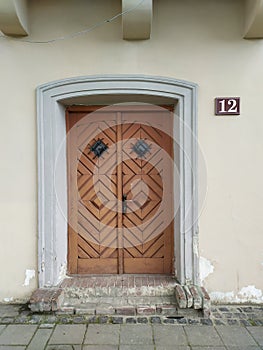 Old wooden door on houses facade with number 12