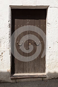 old wooden door with iron door handles at noon