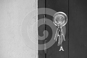 Old wooden door key knob with keys.