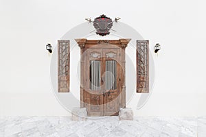 Old wooden door and lantern on white concrete cement wall background.