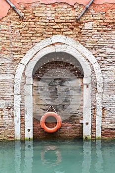 Old wooden door with lifebelt in Venice( Italy)