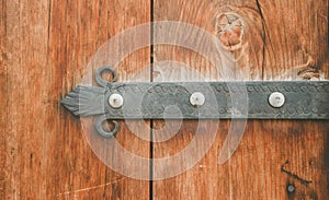 Old wooden door with metal decoration. Photo depicts antique entrance gate, made of wood, temple house with medieval detail.