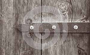 Old wooden door with metal decoration. Photo depicts antique entrance gate, made of wood, temple house with medieval detail.