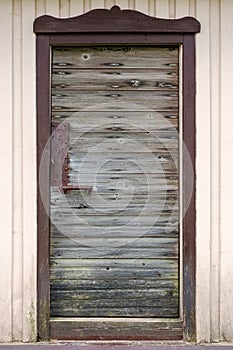 Old wooden door with metal handle, lock and old rusted planks
