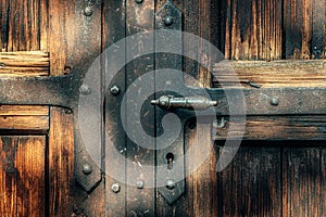 Old wooden door with metal reinforcements and brass handle