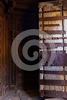 Old wooden door open, entrance to the church in Soria