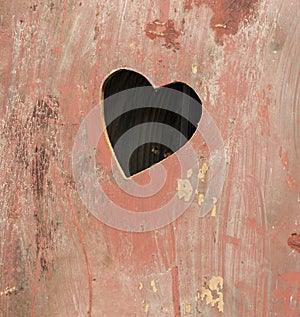 Old wooden door of an outhouse toilet with a heart shaped hole cut in