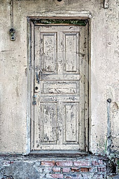 An old wooden door with peeling paint, padlocked