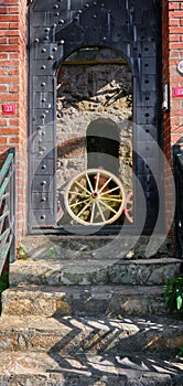 Old wooden door with a red handle, wooden horse-drawn carriage