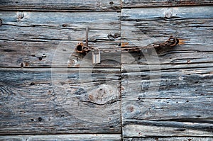 Old wooden door with rusty chain and padlock