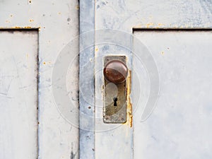 Old wooden door with a rusty round handle