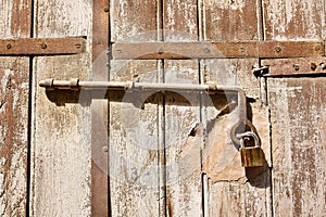 Old wooden door with scratches texture and a hanging lock