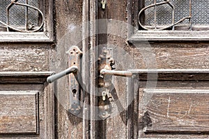 Old wooden door of a shabby demaged house facade. A small town in the mountains of Slovenia, Europe.