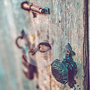 Old wooden door with a vintage handle, hook, lock and mesh. Boho style